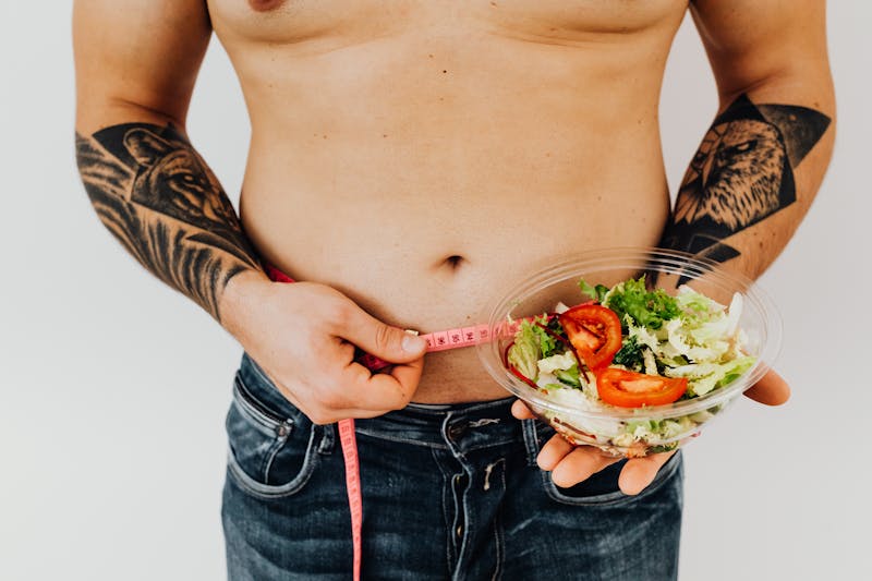 Man measuring waist with tape measure — weight loss program